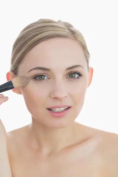 Close-up portrait of young woman putting on make-up — Stock Photo, Image