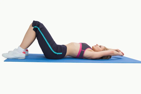 Spor giyim yoga mat üzerinde yatan kadın yan görünüm — Stok fotoğraf