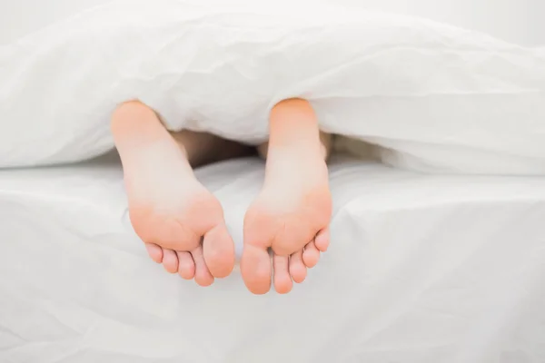Πόδια της γυναίκας, να βγαίνει από την κουβέρτα — Φωτογραφία Αρχείου