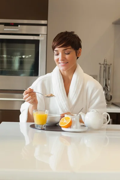 Frau im Bademantel beim Frühstück — Stockfoto