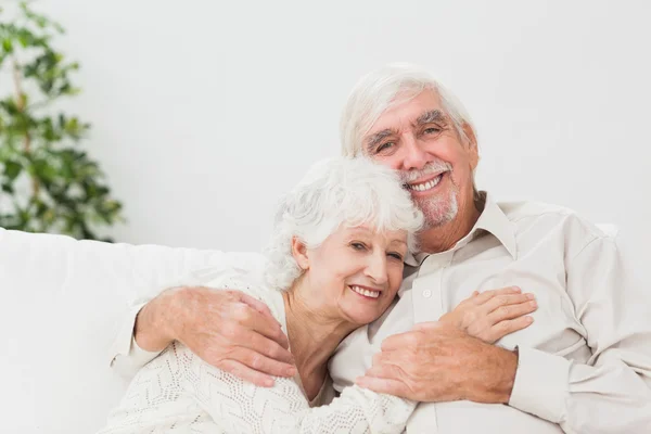 Casal abraçando no sofá — Fotografia de Stock