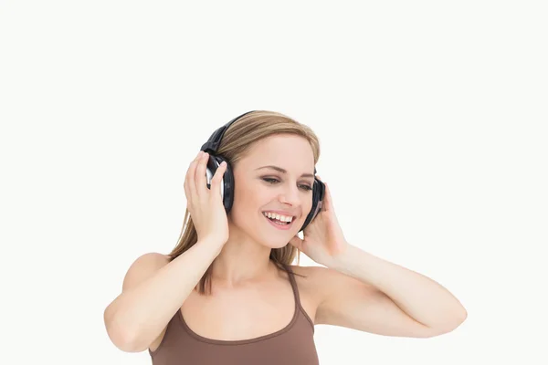 Young woman listening music through headphones — Stock Photo, Image