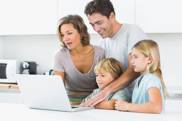 Familia feliz usando el ordenador portátil — Foto de Stock