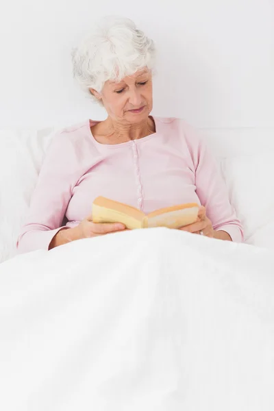 Lezende vrouw in bed — Stockfoto