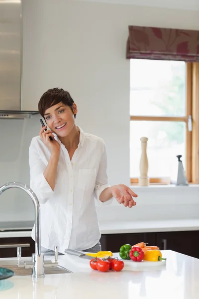 Mujer llamando en su cocina — Foto de Stock