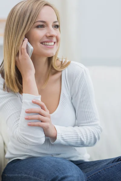 Casual jonge vrouw met behulp van mobiele telefoon thuis — Stockfoto