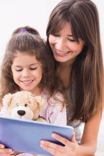 Счастливые мать и дочь с помощью планшетного компьютера — стоковое фото