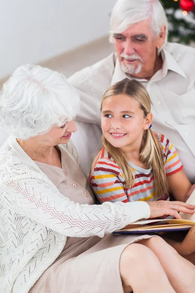 Abuelos con nieta leyendo — Foto de Stock