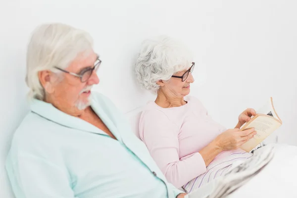 Mann und Frau lesen im Bett — Stockfoto