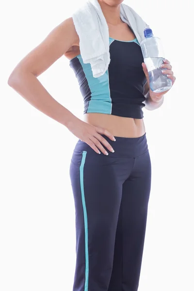 Deportiva mujer con toalla alrededor del cuello y botella de agua —  Fotos de Stock