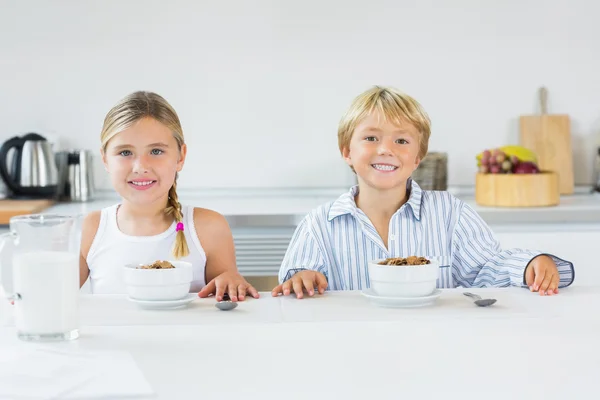 Brother and sister having breakfast — Stock Photo, Image