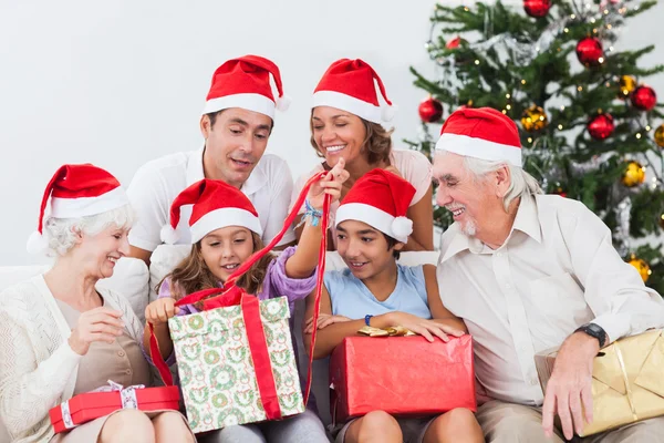 Familia viendo niña abriendo regalo de Navidad — Foto de Stock