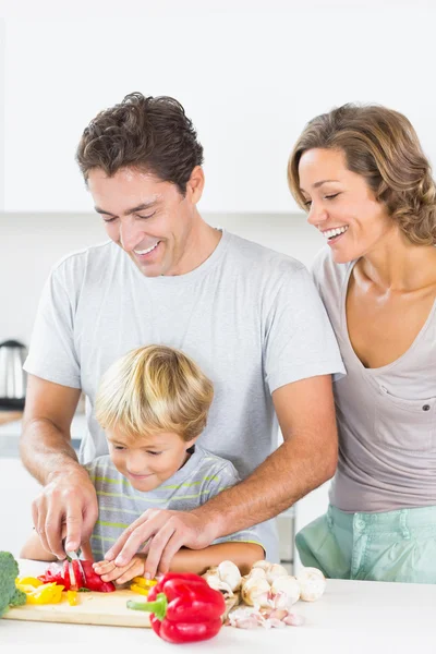 Mãe assistindo como filho e marido preparar legumes — Fotografia de Stock