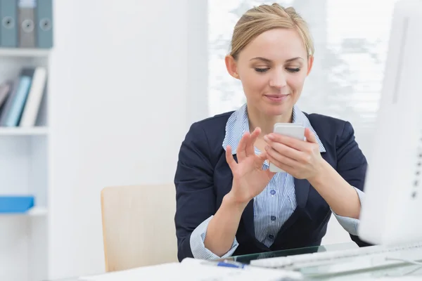Business woman text messaging at office desk — Stock Photo, Image