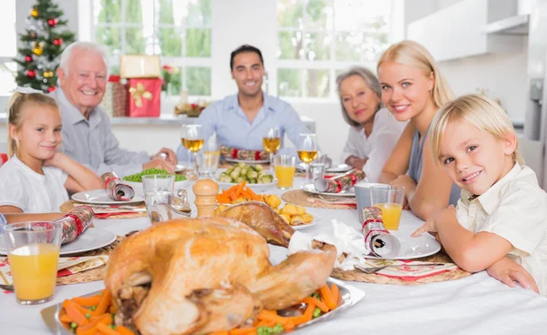 Focus on the roast turkey in front of family Royalty Free Stock Photos