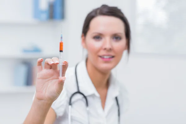 Médica mulher segurando uma injeção — Fotografia de Stock