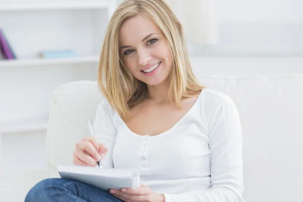 Young woman with notepad and pen at home Stock Image