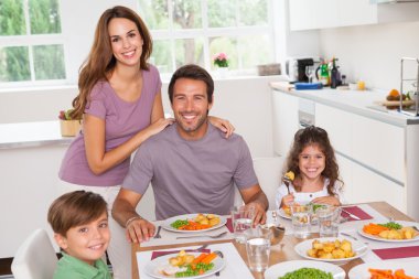 Family smiling at the dinner table clipart