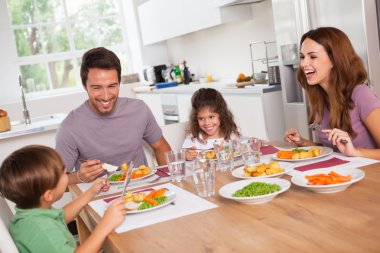 Family laughing around a good meal clipart