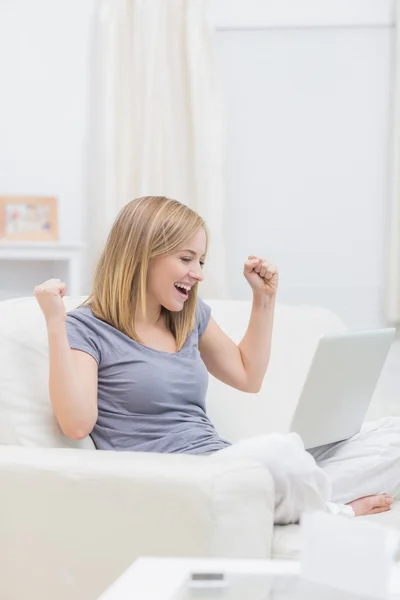 Eccitato donna casual con computer portatile a casa — Foto Stock