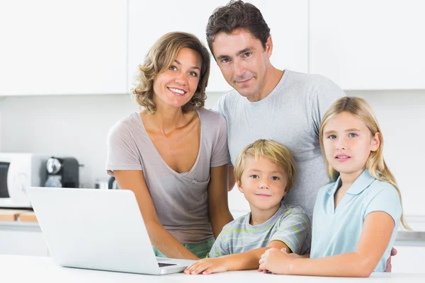 Усміхнена сім'я з ноутбуком — стокове фото