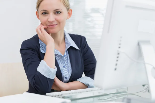 Femme d'affaires confiante avec ordinateur au bureau — Photo