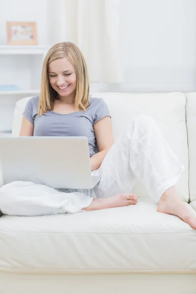 轻松快乐的女人在沙发上使用便携式计算机 — 图库照片