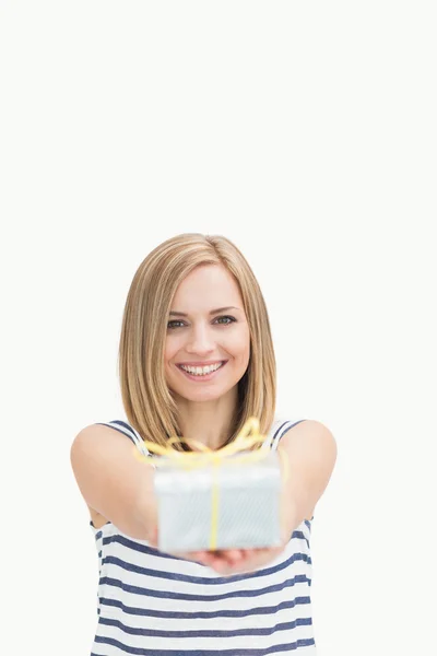 Portrait of cute young woman holding out gift box — Stock Photo, Image