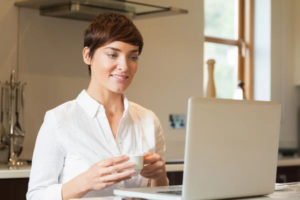 Frau benutzt Laptop und trinkt Kaffee — Stockfoto