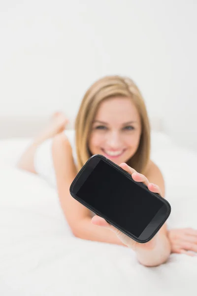 Mulher mostrando-lhe seu novo smartphone na cama — Fotografia de Stock