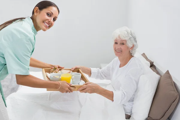 Hem sjuksköterska ger en frukost till gumman — Stockfoto