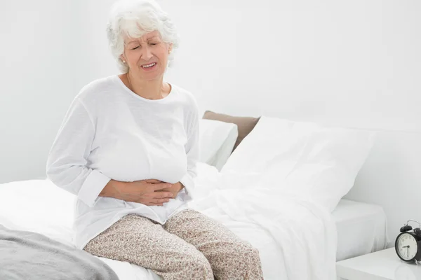Velha mulher sofrendo com dor de barriga — Fotografia de Stock