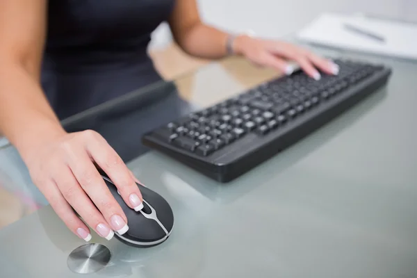 Woman using computer mouse and keyboard at desk — Stock Photo, Image