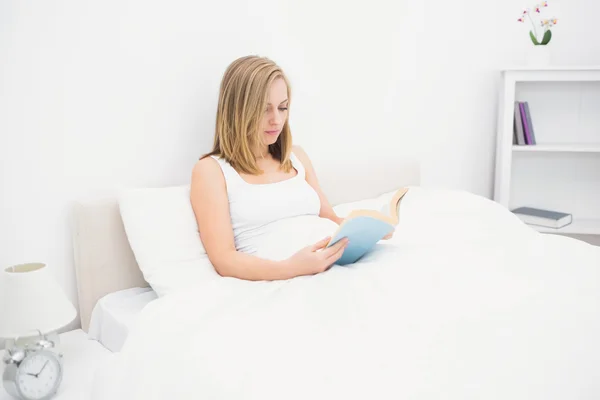 Woman reading book in bed — Stock Photo, Image