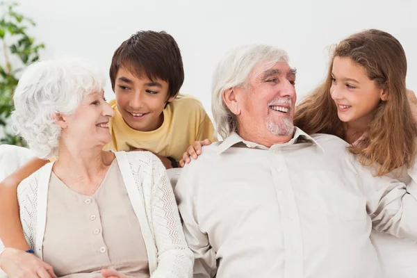 Бабушка и дедушка с внуками на диване — стоковое фото
