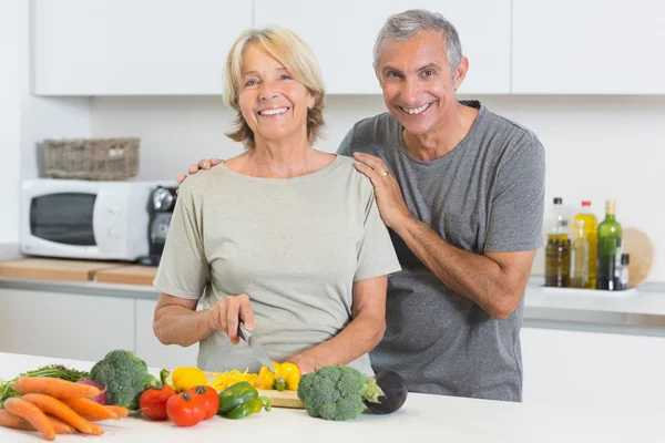 Couple heureux coupant des légumes ensemble — Photo