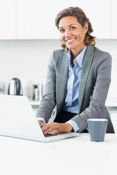 Femme tapant sur ordinateur portable dans la cuisine avant le travail — Photo