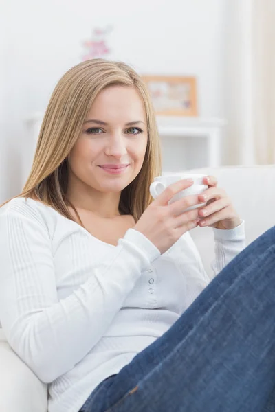 Retrato de mujer con taza de café sentado en el sofá — Foto de Stock