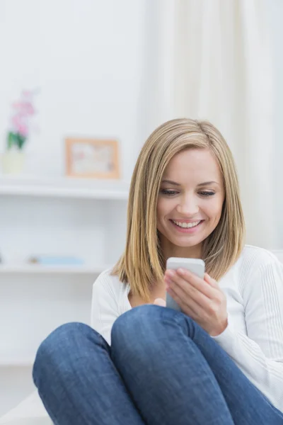 Mujer feliz con teléfono móvil en casa — Foto de Stock