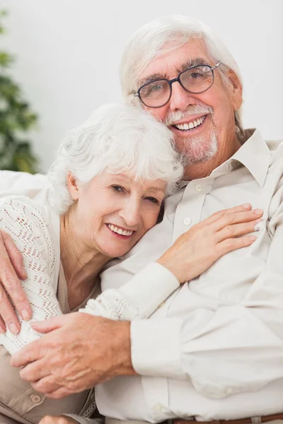 Couple embracing on couch — Stock Photo, Image