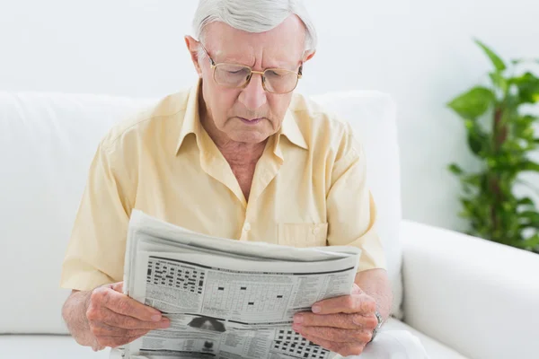 Konzentrierter älterer Mann liest die Nachrichten — Stockfoto