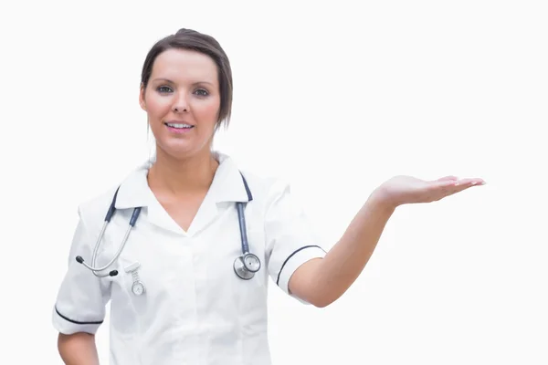 Portrait of female nurse holding out open palm — Stock Photo, Image