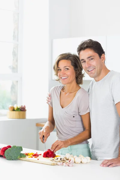 Smiling wife chopping vegetables with husband — Stock Photo, Image