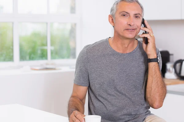 Člověk pije při telefonování — Stock fotografie