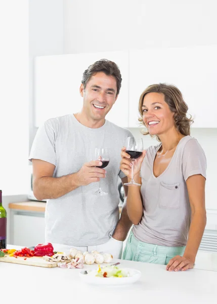 Paar trinkt Rotwein und bereitet Salat zu — Stockfoto