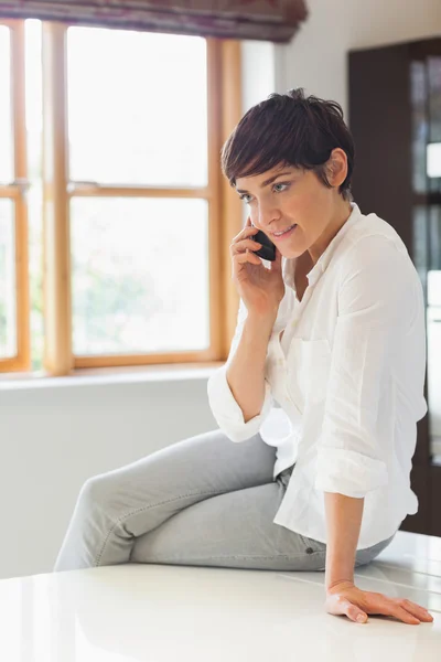 Mujer llamando sentado en el sofá — Foto de Stock