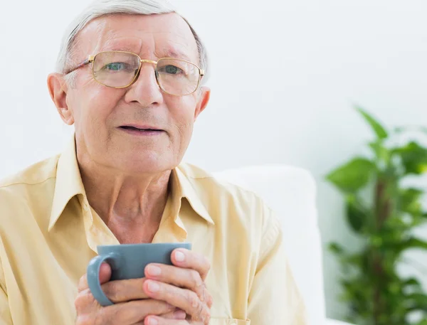 Oudere man met een kop — Stockfoto