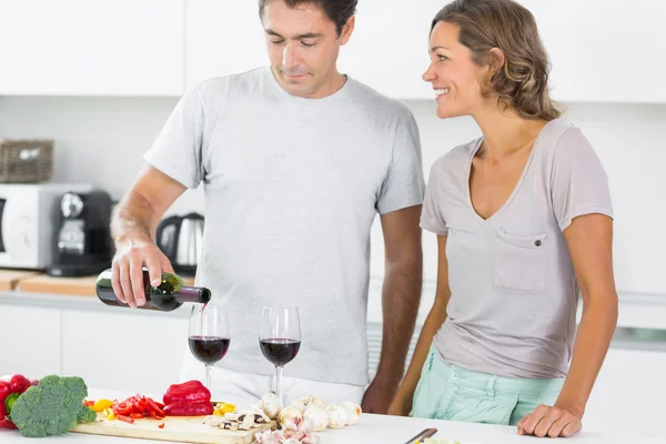 Kocasını mutfakta kırmızı şarap dökme — Stok fotoğraf