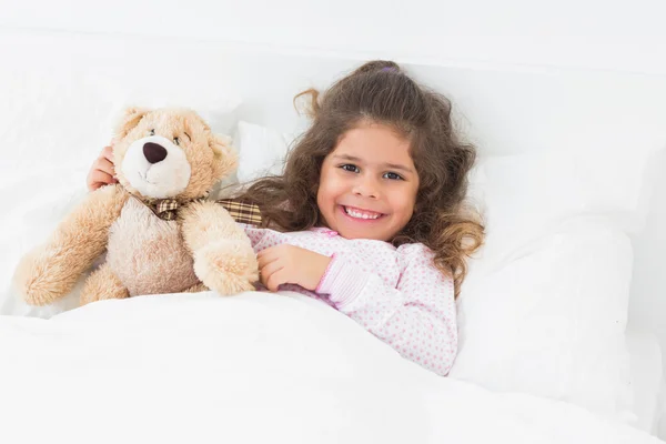 Küçük kız yatakta oyuncak ayı ile — Stok fotoğraf