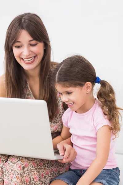 Mãe feliz e filha usando laptop — Fotografia de Stock